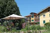Collective enquiries © Ferienhotel Herzog Garden with gazebo and colorful flowers in front of colorful residential building