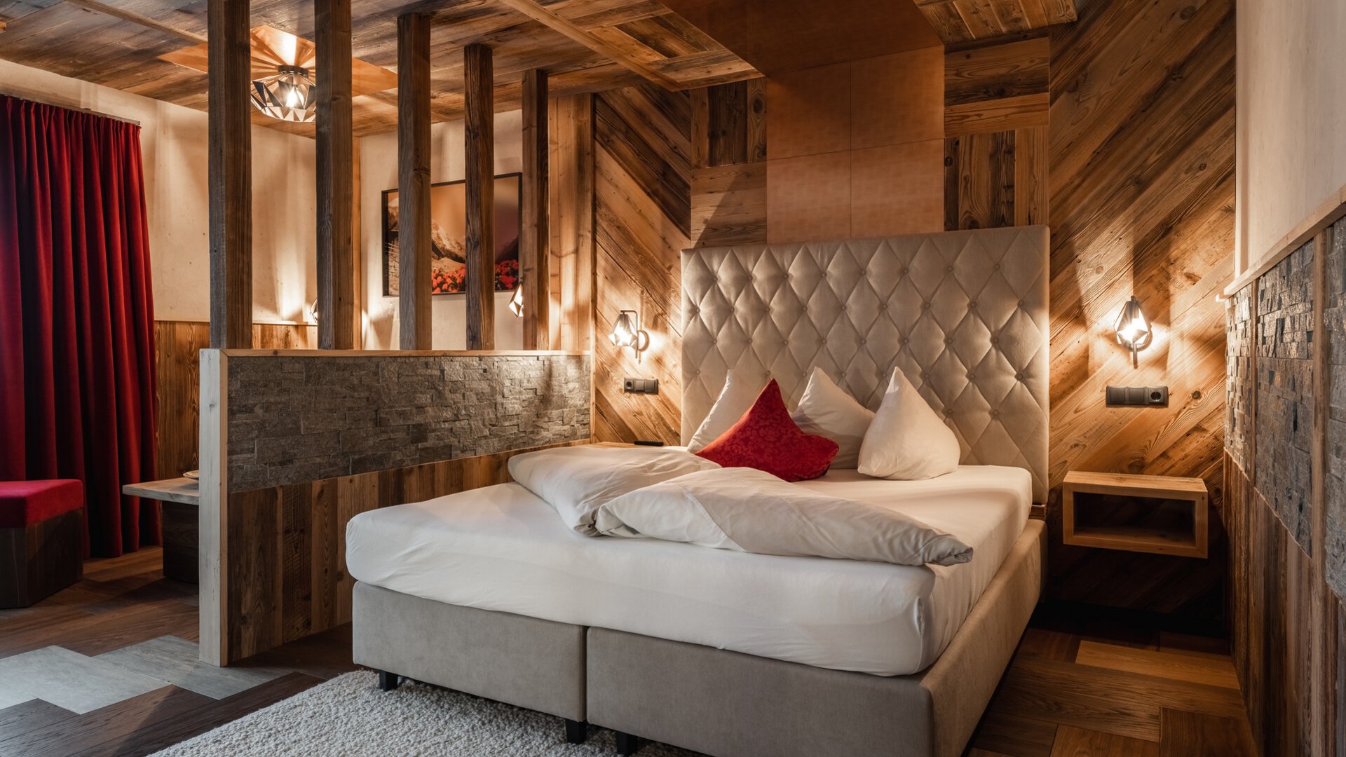 Cozy bedroom with wooden walls and red accent pillow