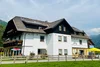 Collective enquiries Large white house with brown roof and mountains in the background