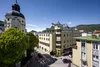 Historische Gebäude und grüne Bäume in einer sonnigen Stadt bei blauem Himmel