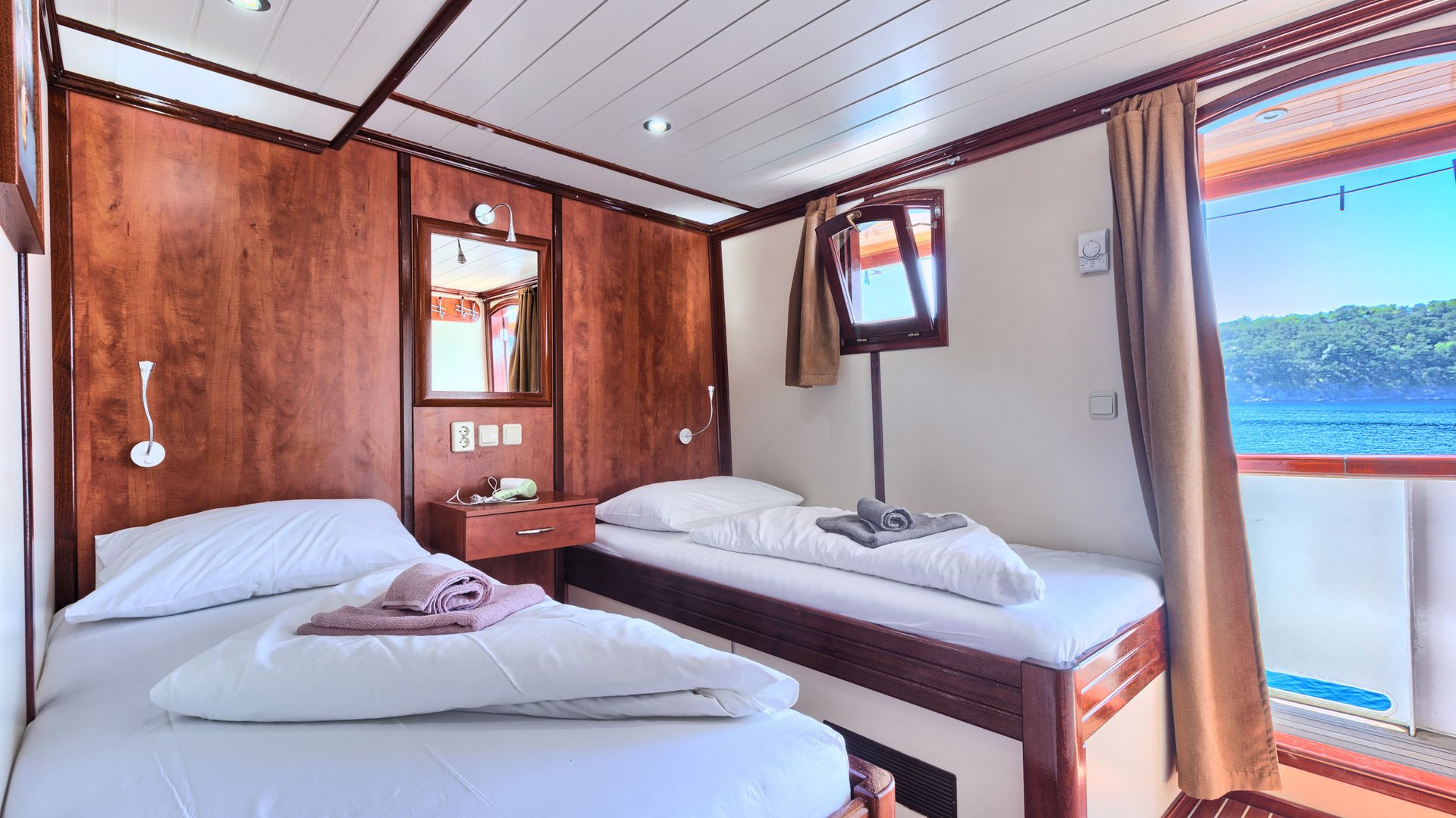 Cabin with two single beds on a boat overlooking the water