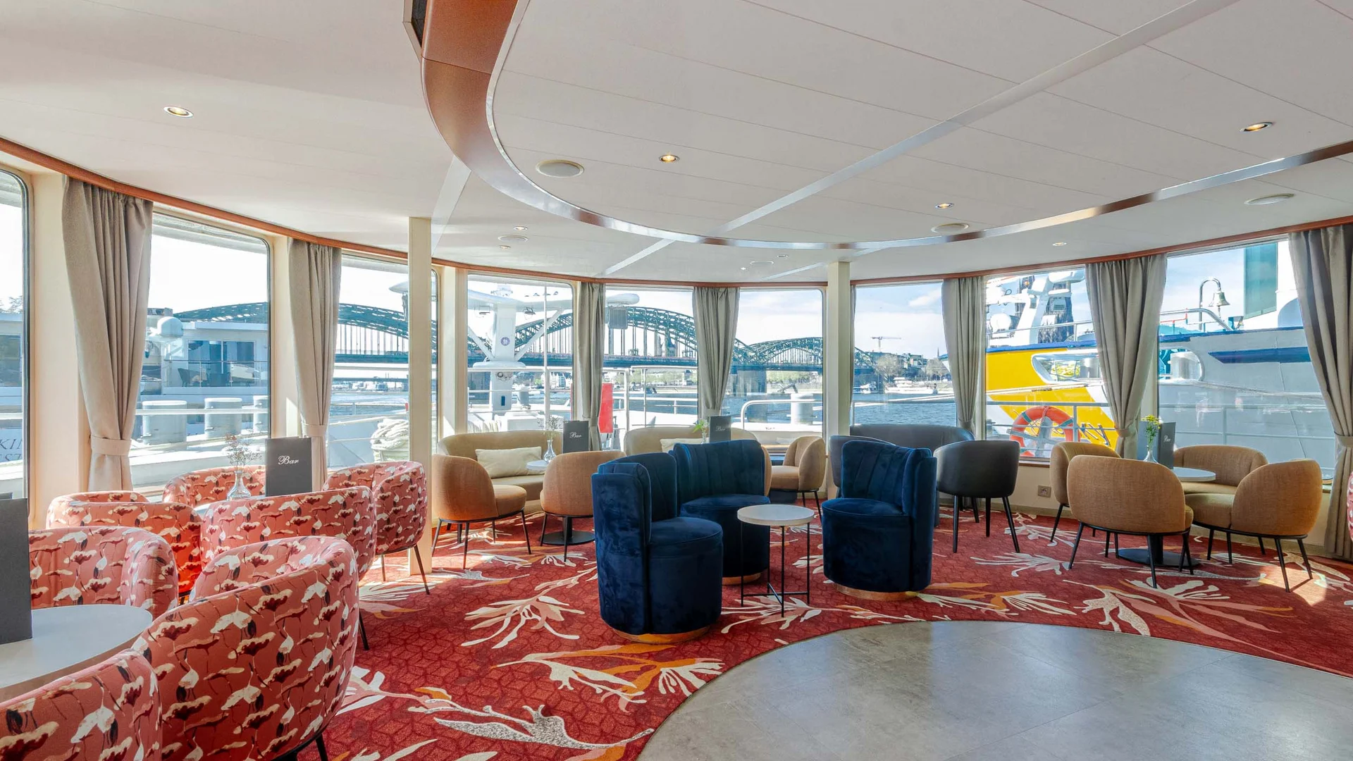 Cycle tour between Passau and Vienna © Rad+Reisen - Tobias Bayer Cozy indoor seating area with large windows showing a bridge and harbor outside