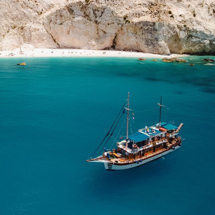 Sailboat on blue sea near white cliffs and beach