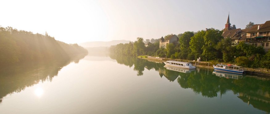 River with boats and town in morning light