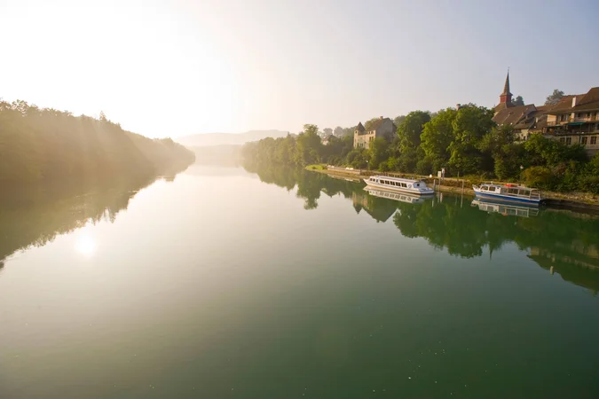 Fluss mit Booten und Stadt im Morgenlicht