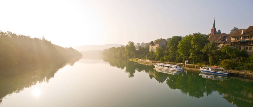 River with boats and town in morning light