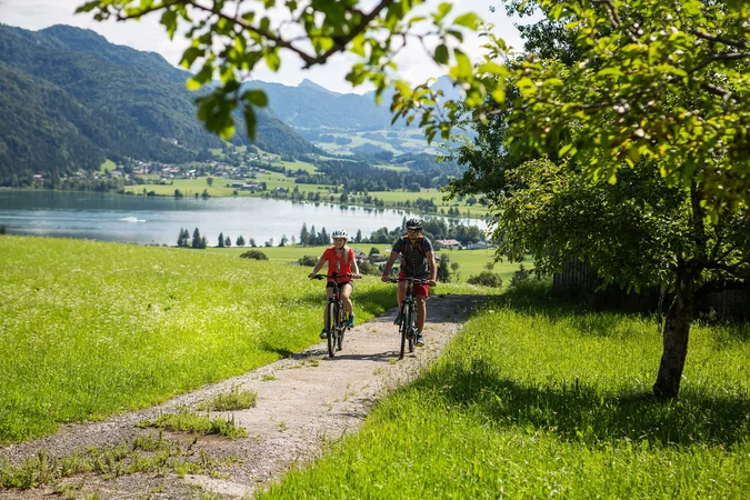 Zwei Fahrradfahrer auf einem Weg mit Blick auf See und Berge