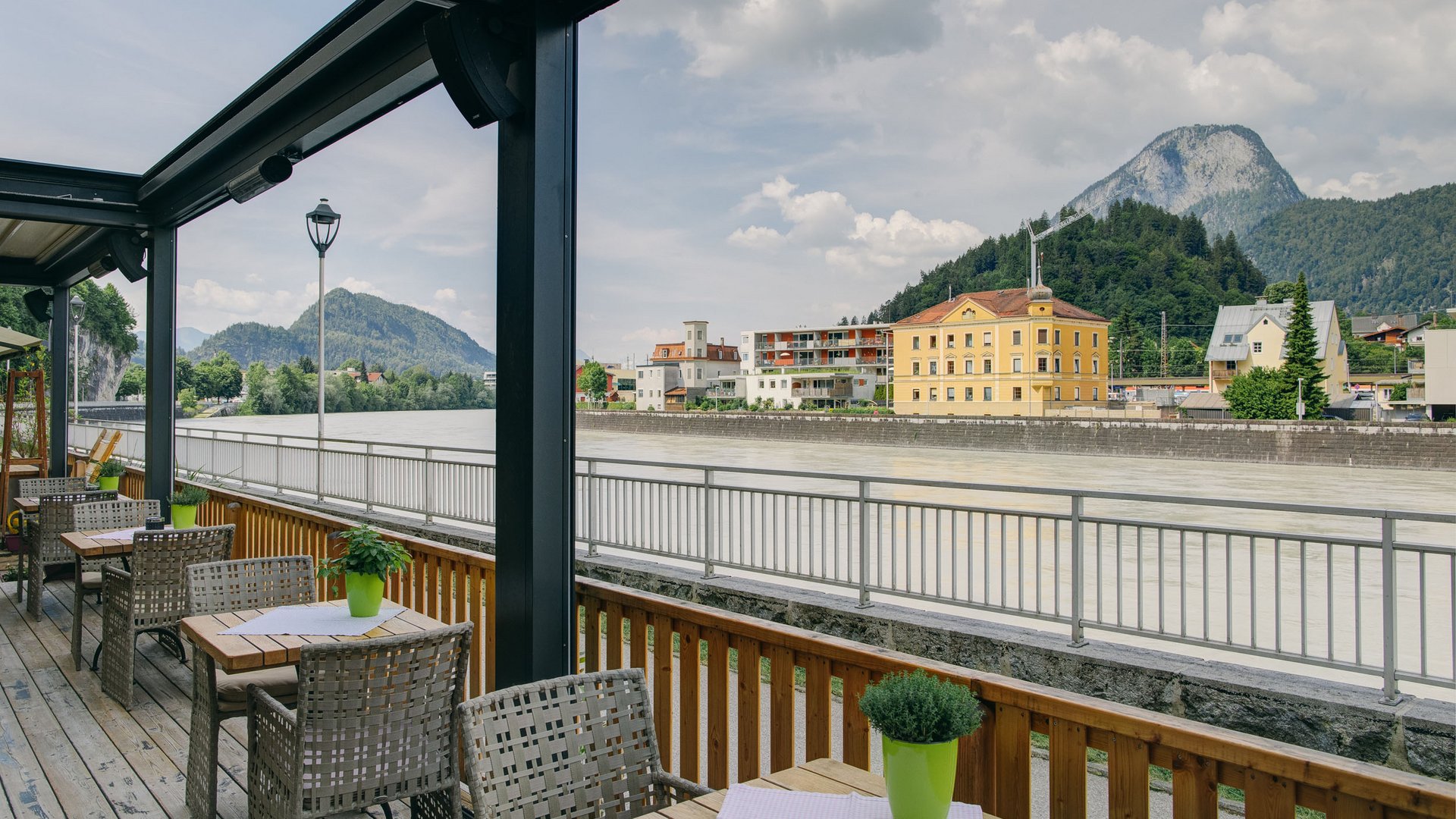 Terrace view of river and mountains with tables and chairs