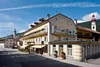 Collective enquiries © Foto Klick Yellow hotel with flowers on balconies in sunny village with church and mountains