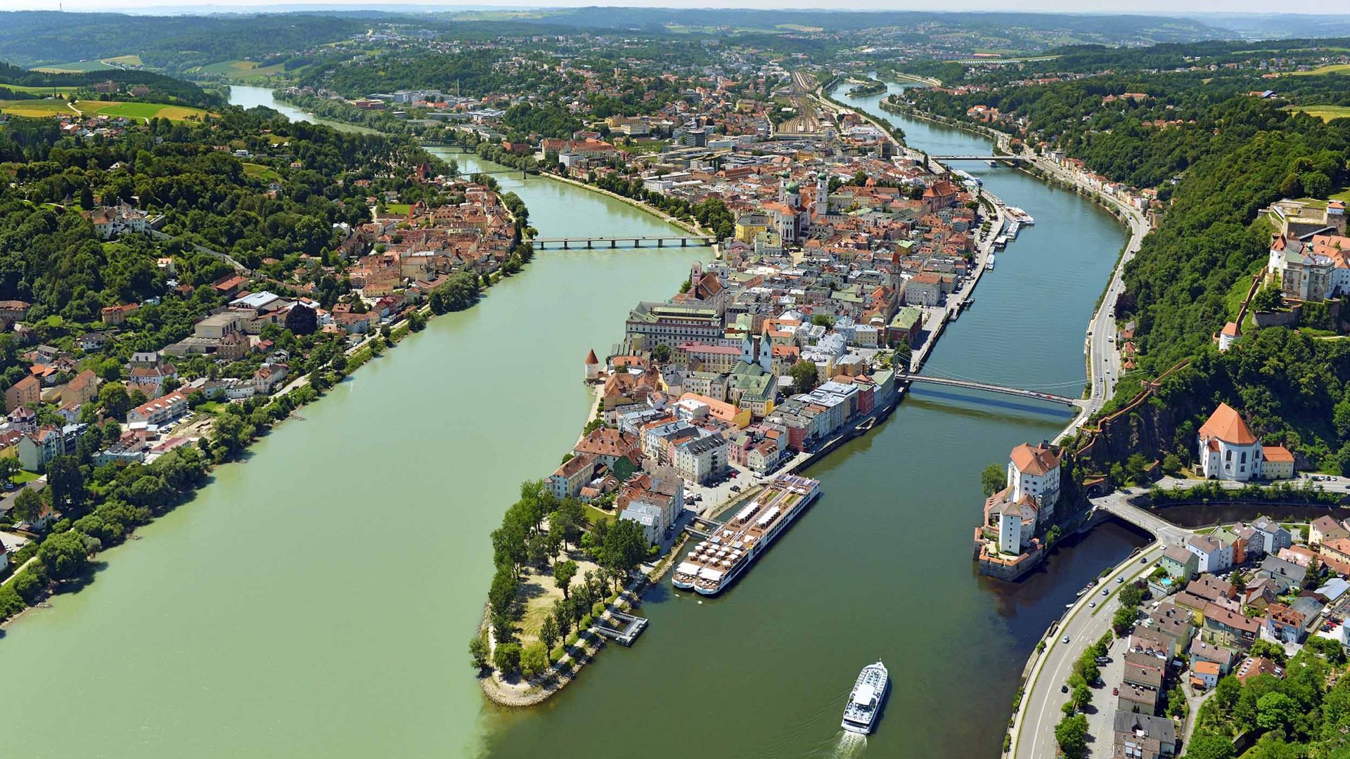 Aerial view of Passau showing the confluence of the Danube, Inn, and Ilz rivers with a boat