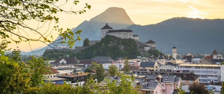 Blick auf die Stadt Kufstein mit der Festung und Bergen im Sonnenuntergang