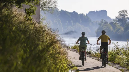 Radfahren ohne Höhenmeter-Stress im Quellenviertel © Velontour - Heiko Mandl Zwei Radfahrer auf einem Flussweg bei sonnigem Wetter