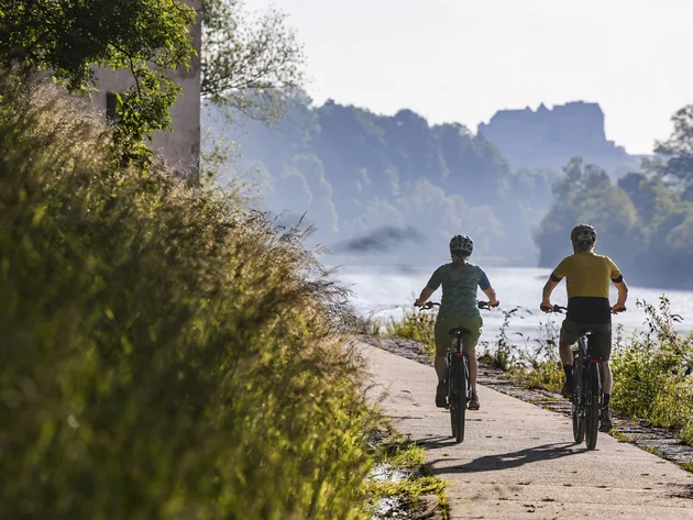 Radfahren ohne Höhenmeter-Stress im Quellenviertel © Velontour - Heiko Mandl Zwei Radfahrer auf einem Flussweg bei sonnigem Wetter