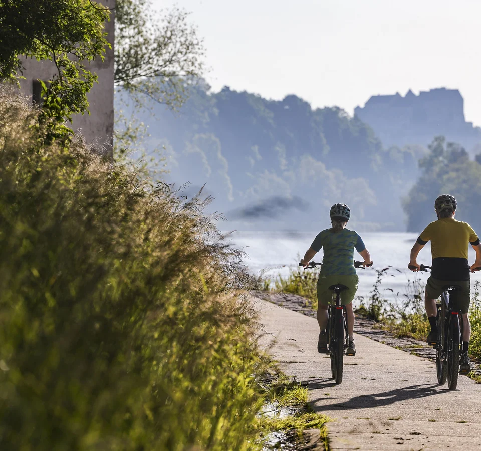 7 Quellen der Entschleunigung © Velontour - Heiko Mandl Zwei Radfahrer auf einem Flussweg bei sonnigem Wetter