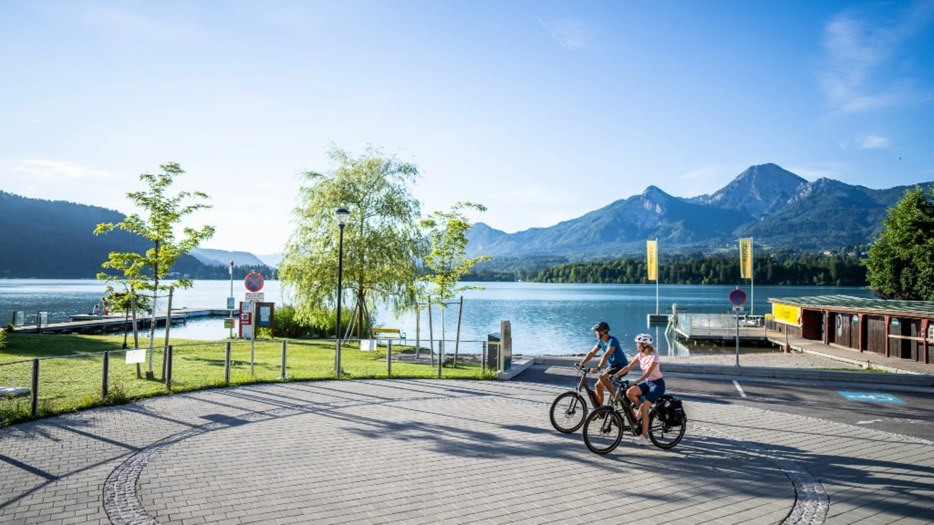 Twee fietsers bij het meer met bergen op de achtergrond