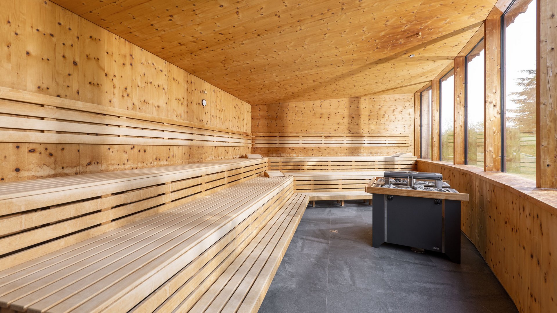 Modern sauna interior with wooden benches and large windows