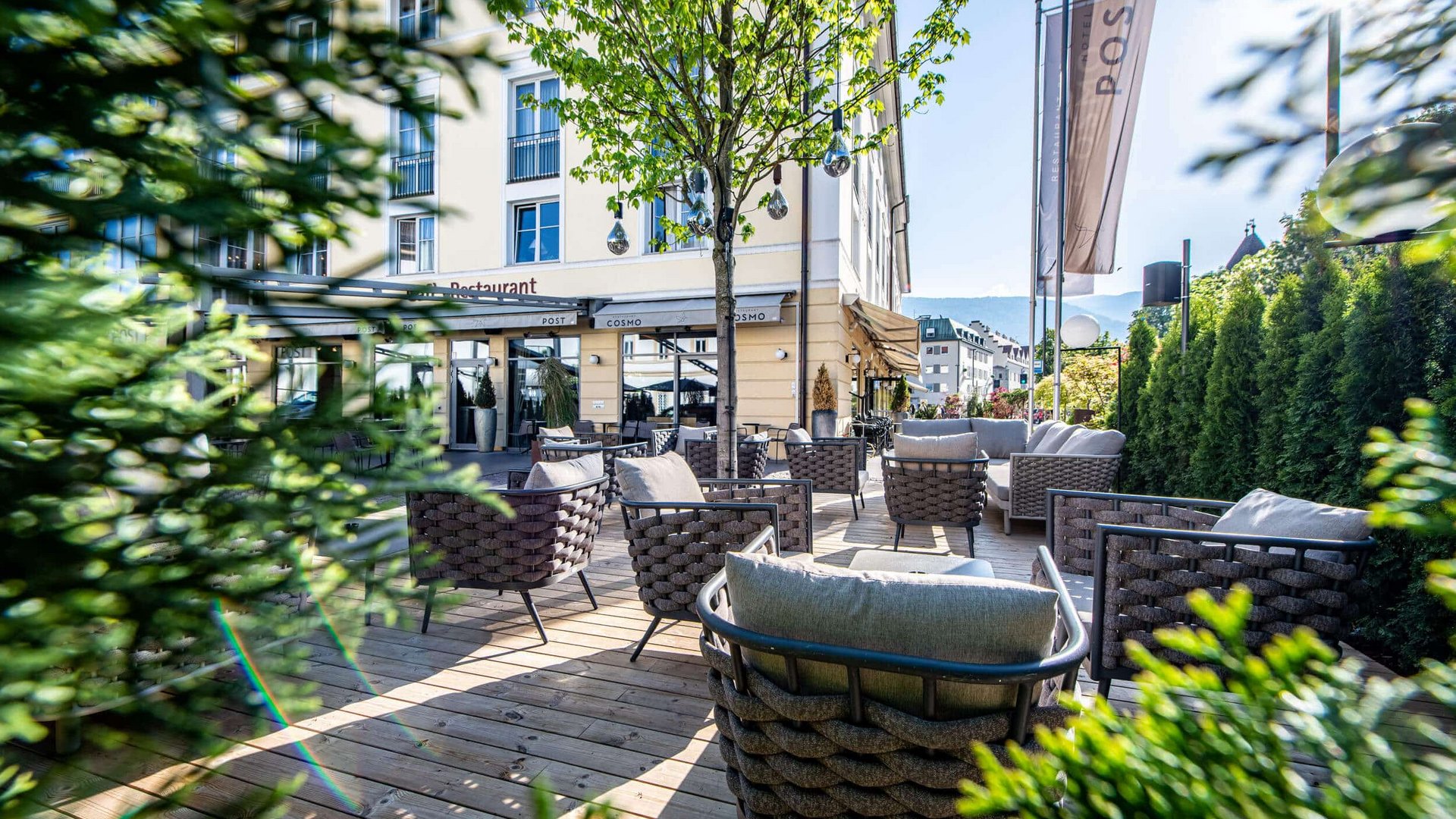 Cozy restaurant terrace with seating and trees on a sunny day