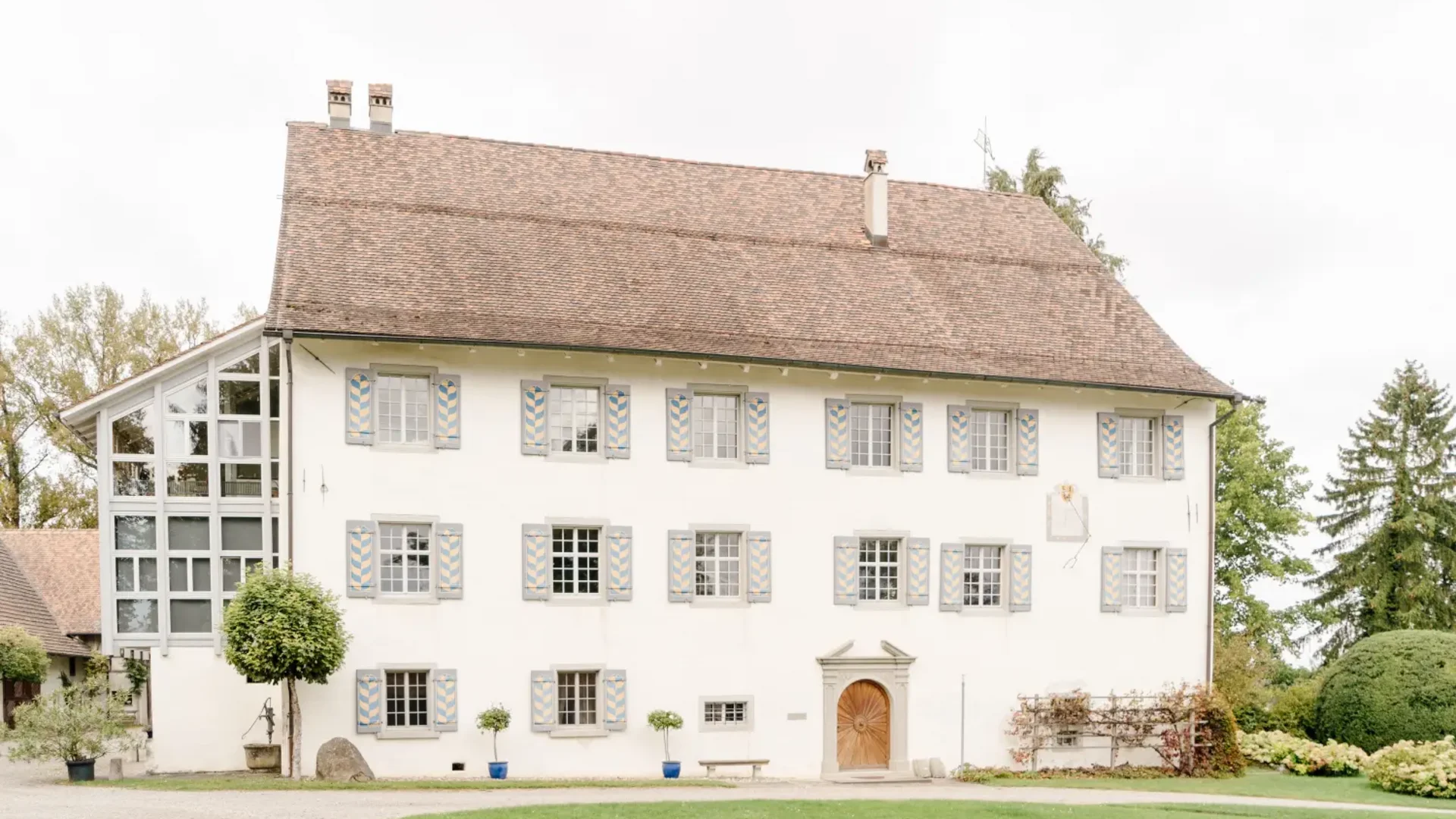 Tour detail © Gudrun Engeler Large old white house with many windows and brown shingle roof