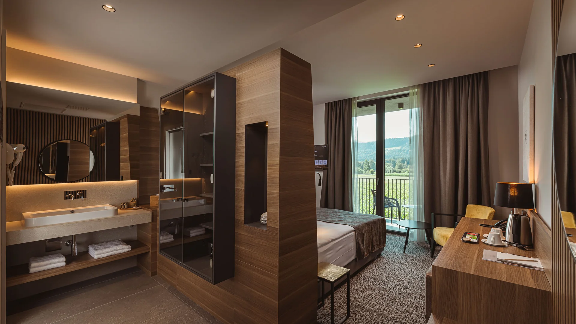 Moderne hotelkamer met bad, bed en balkon met uitzicht op de bergen