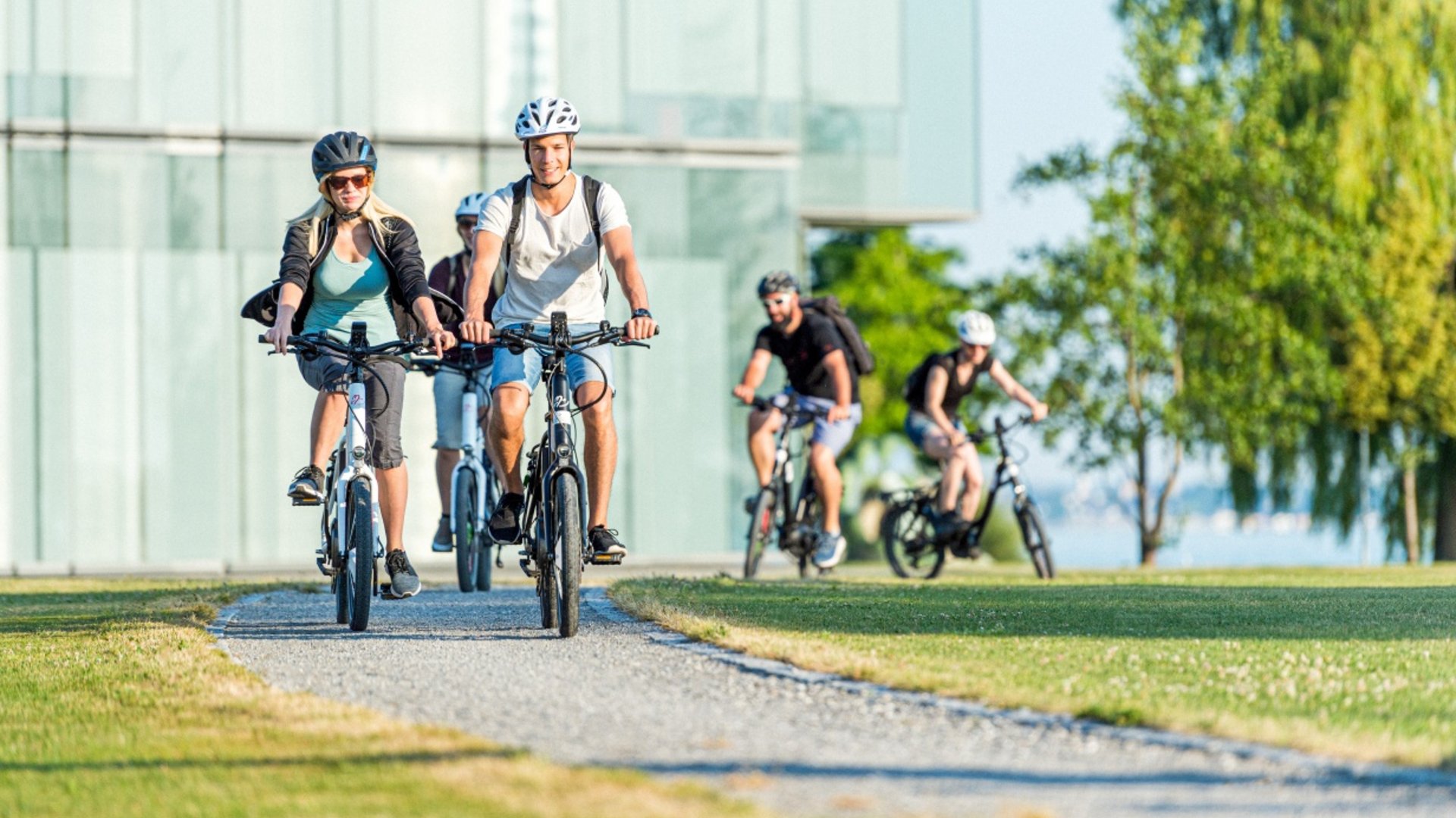 Group of young people cycling on a path in the park.