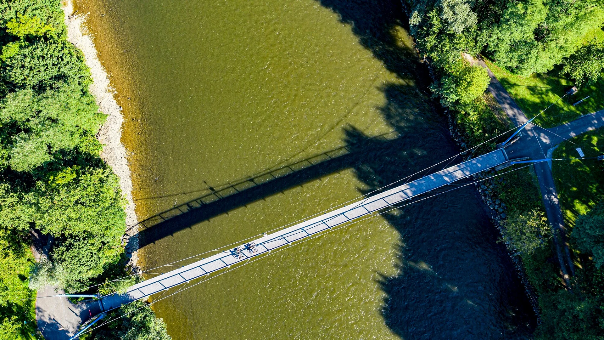 Luchtfoto van hangbrug over rivier met twee fietsers