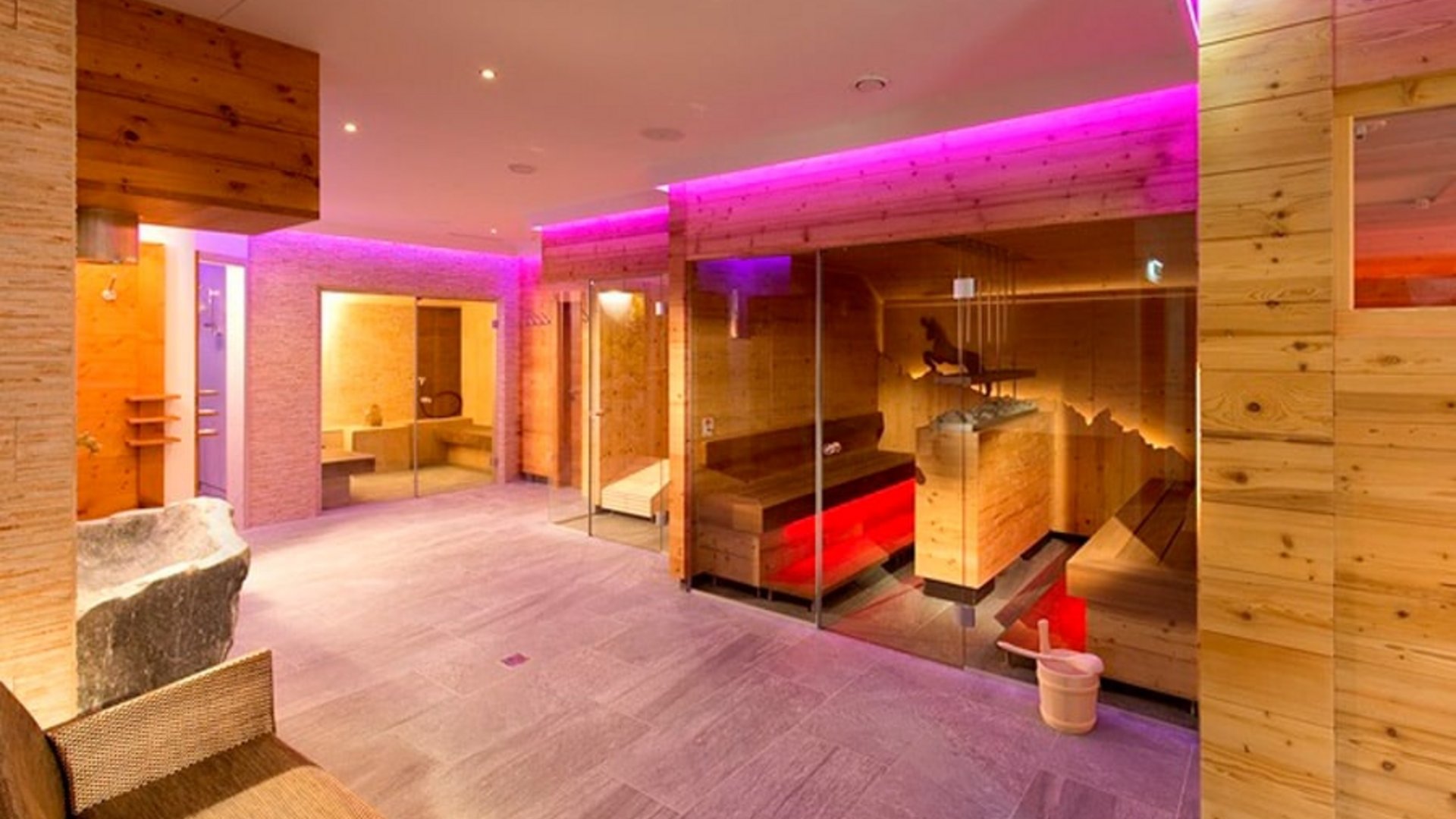 Modern sauna with wooden walls and purple LED lighting