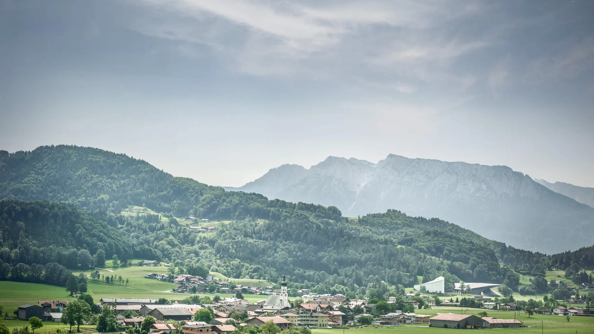 Village with church and mountains in the background on a cloudy day