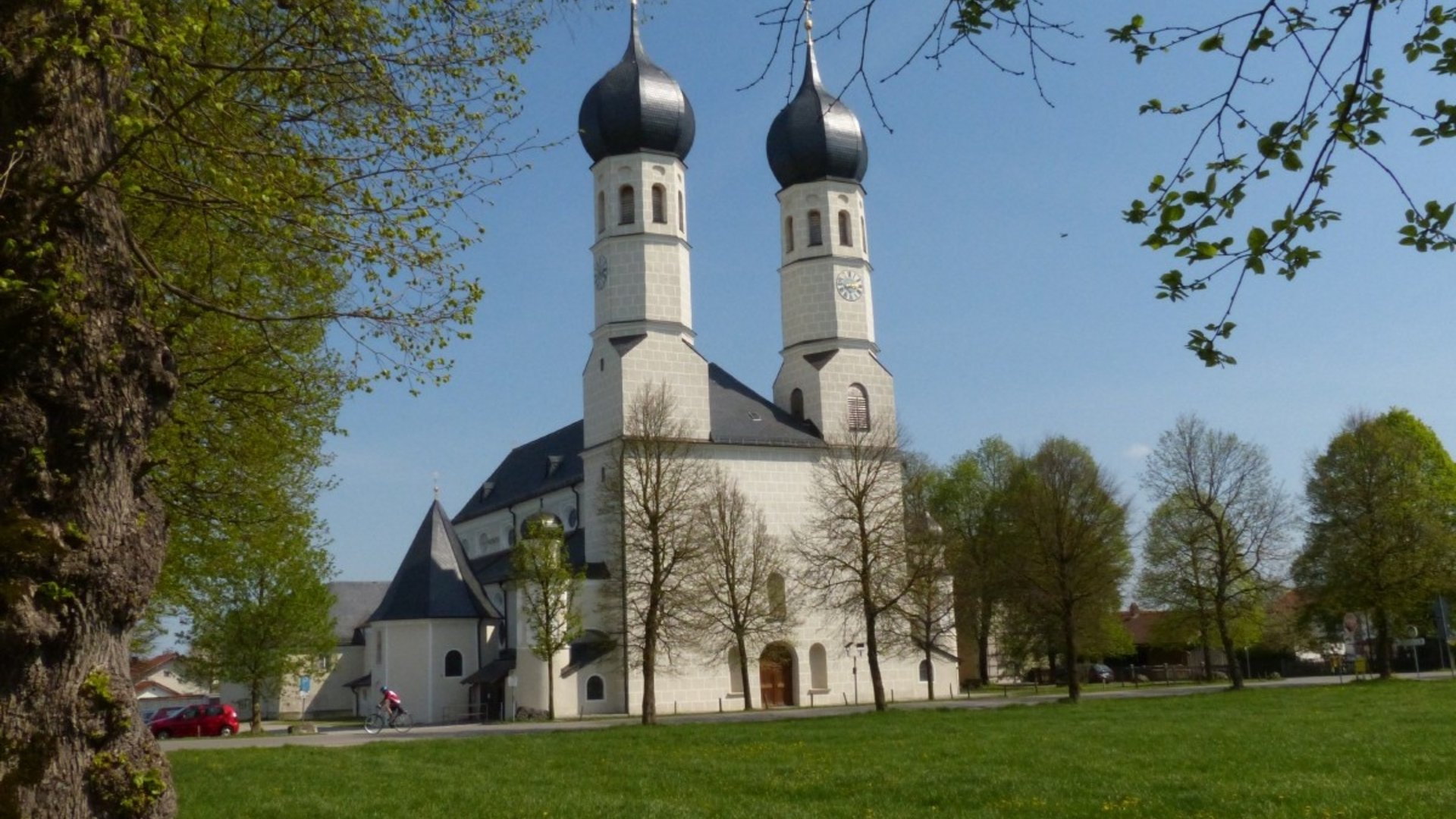 Church with onion domes in a green park area under blue sky