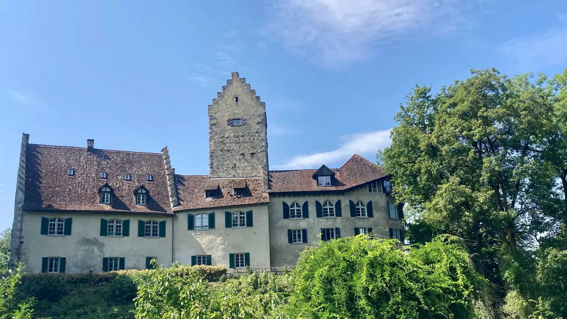 Tour detail © Thurgau Tourismus Old castle with tall tower and green garden under clear blue sky