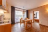 Collective enquiries © Gasthof Residence Brugghof Dining area with wooden table, chairs, kitchenette, and view into bedroom