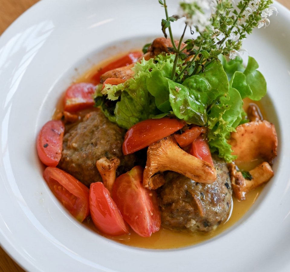 Meatballs with chanterelle mushrooms, tomatoes, and lettuce garnish