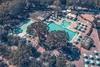 Collective enquiries © Benno Prenn Aerial view of outdoor swimming pools with umbrellas and surrounding trees