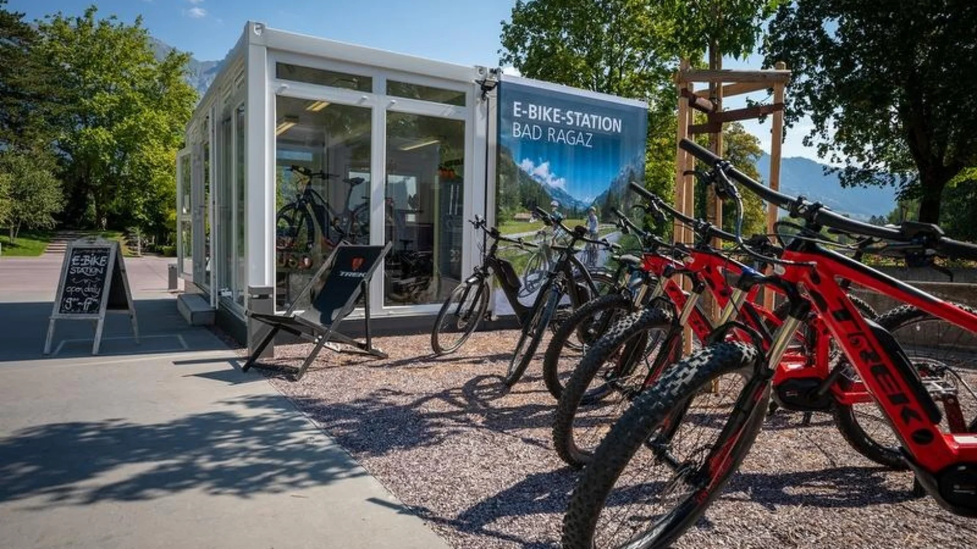 E-bike verhuurstation in Bad Ragaz met meerdere rode e-bikes op een zonnige dag