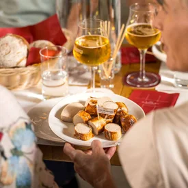 Mensen delen Weense worstjes en bier aan een gedekte tafel