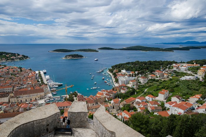 View of coastal town with harbor, islands, and cloudy sky