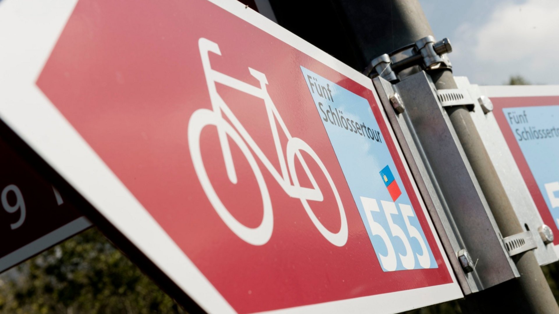 Bike route sign Five Castles Tour 555 on metal pole