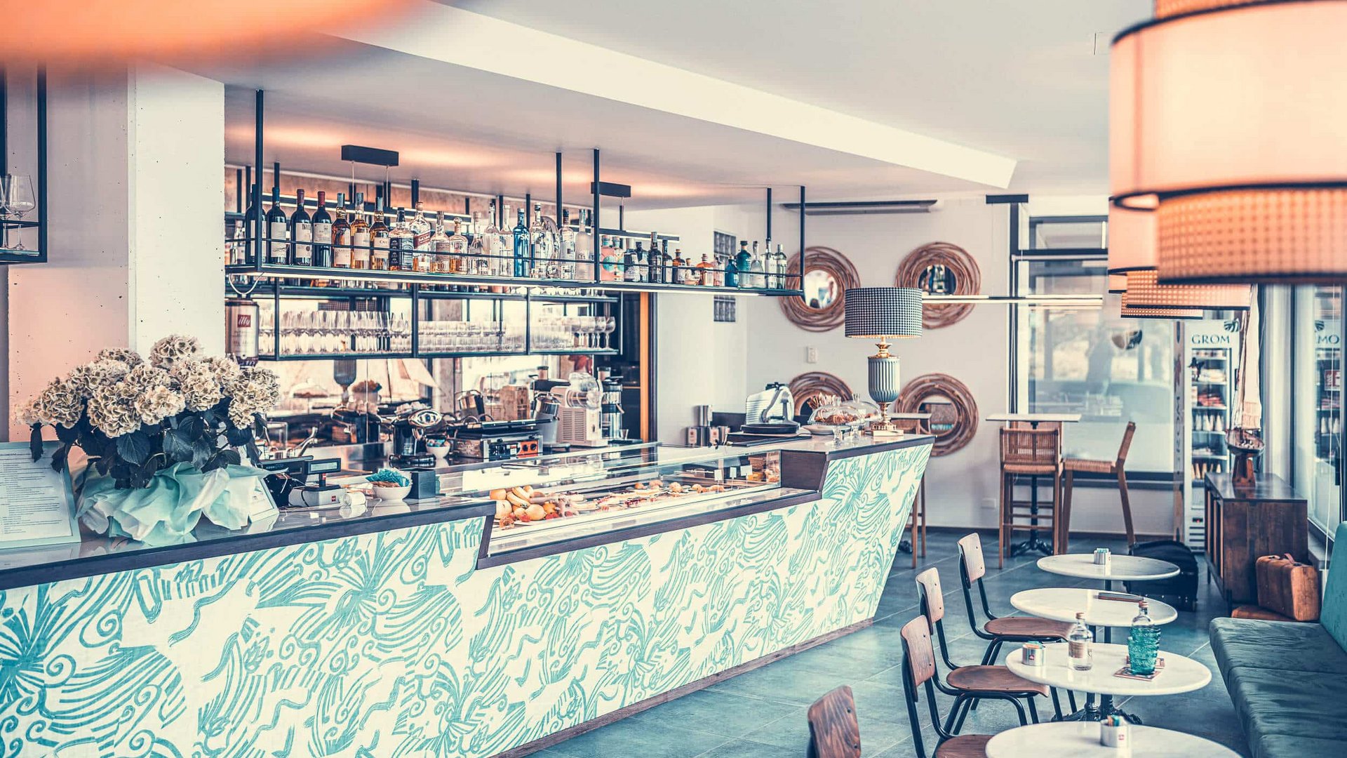 Modern café interior with bar, decorated walls and tables with chairs