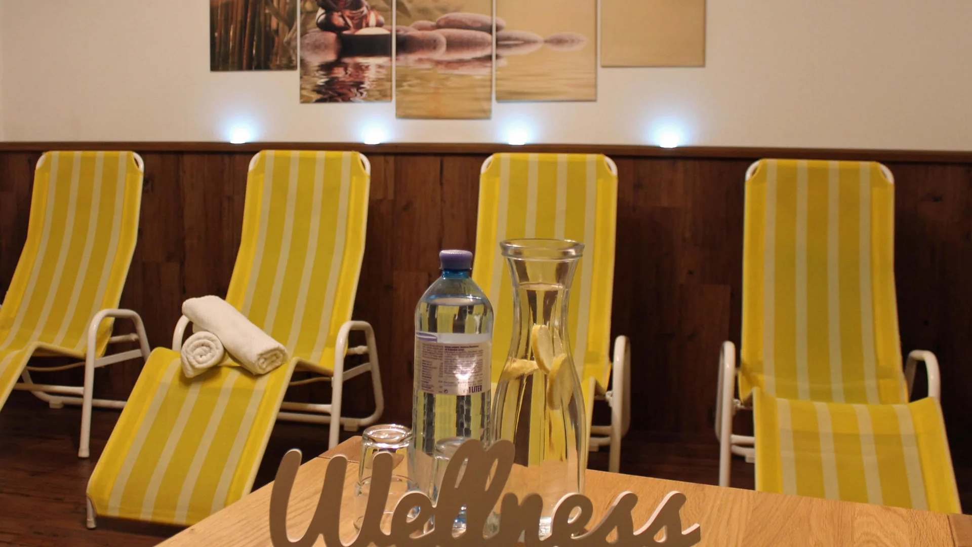 Wellness room with yellow-white striped lounge chairs and water bottles