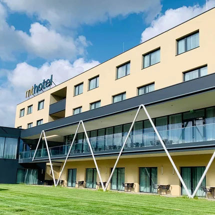 Modernes Hotelgebäude mit grüner Rasenfläche und blauem Himmel