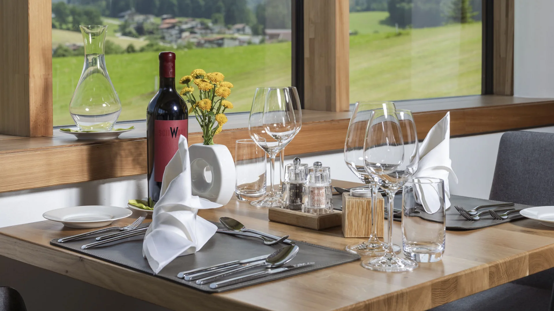 Eleganter gedeckter Esstisch mit Bergblick durchs Fenster