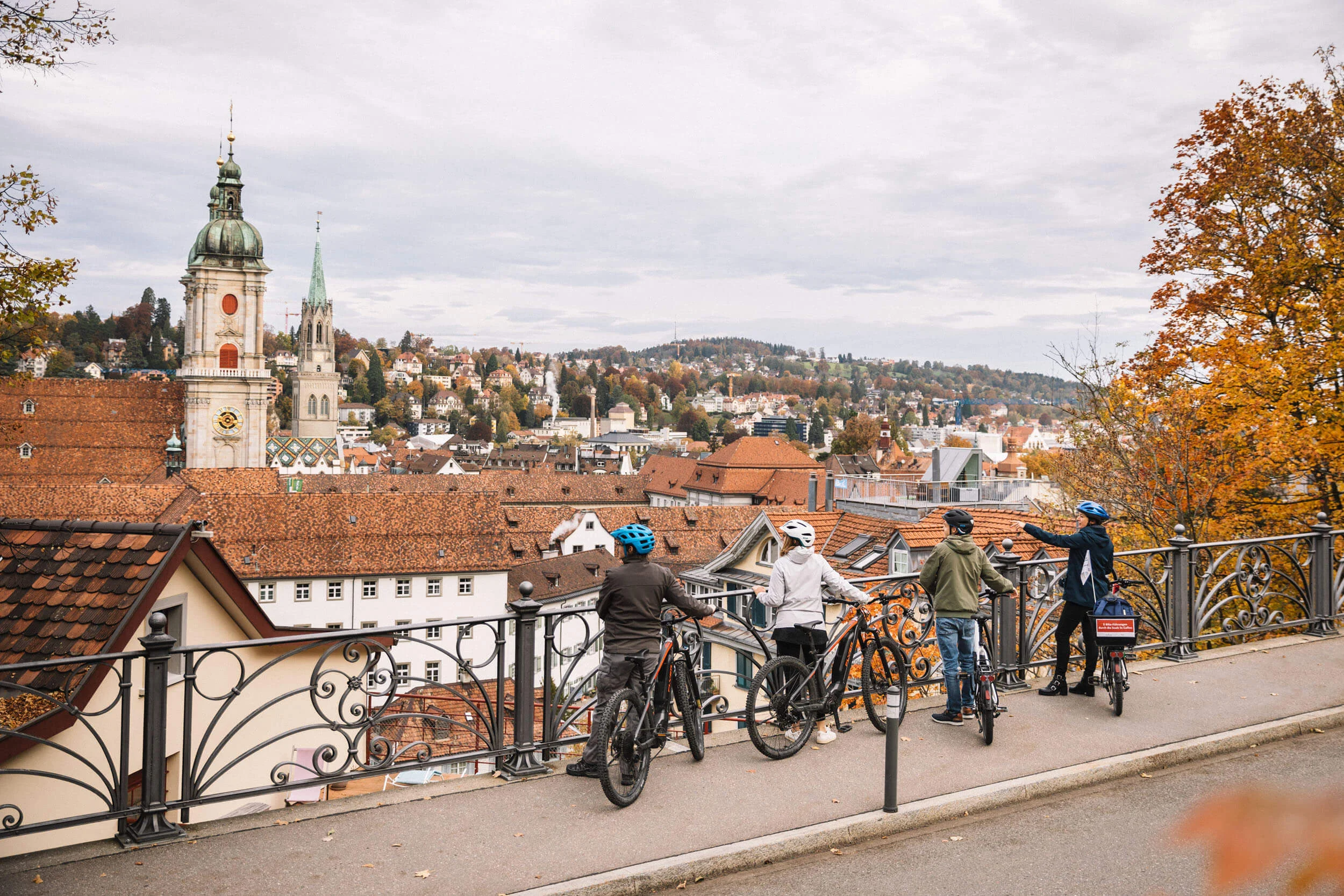 Fahrradfahrer betrachten die Stadt und Herbstlandschaft von einer Aussichtsplattform