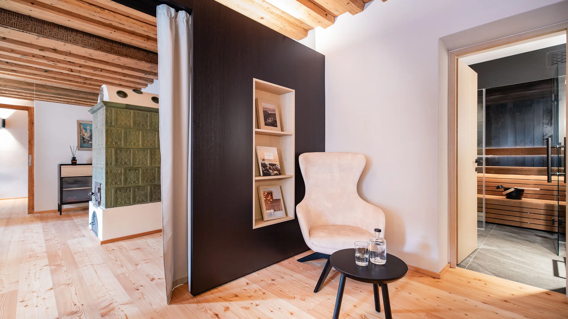 Gezellige zithoek met fauteuil, tafel en sauna in modern houten interieur