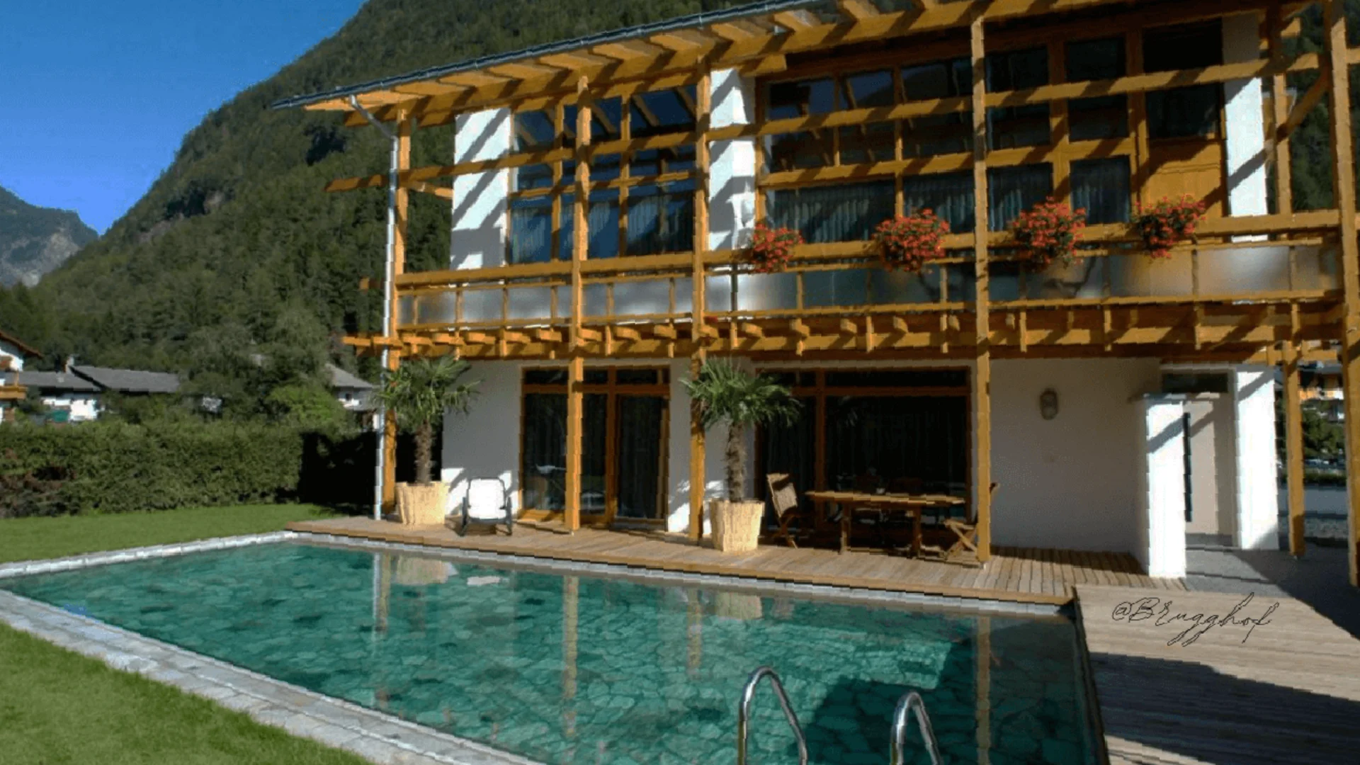 House with wooden veranda and pool in mountainous landscape
