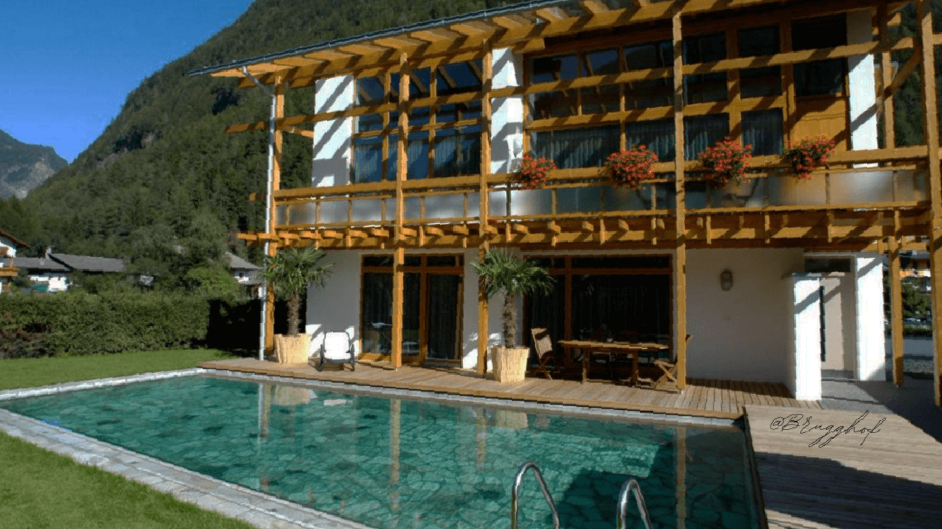 House with wooden veranda and pool in mountainous landscape