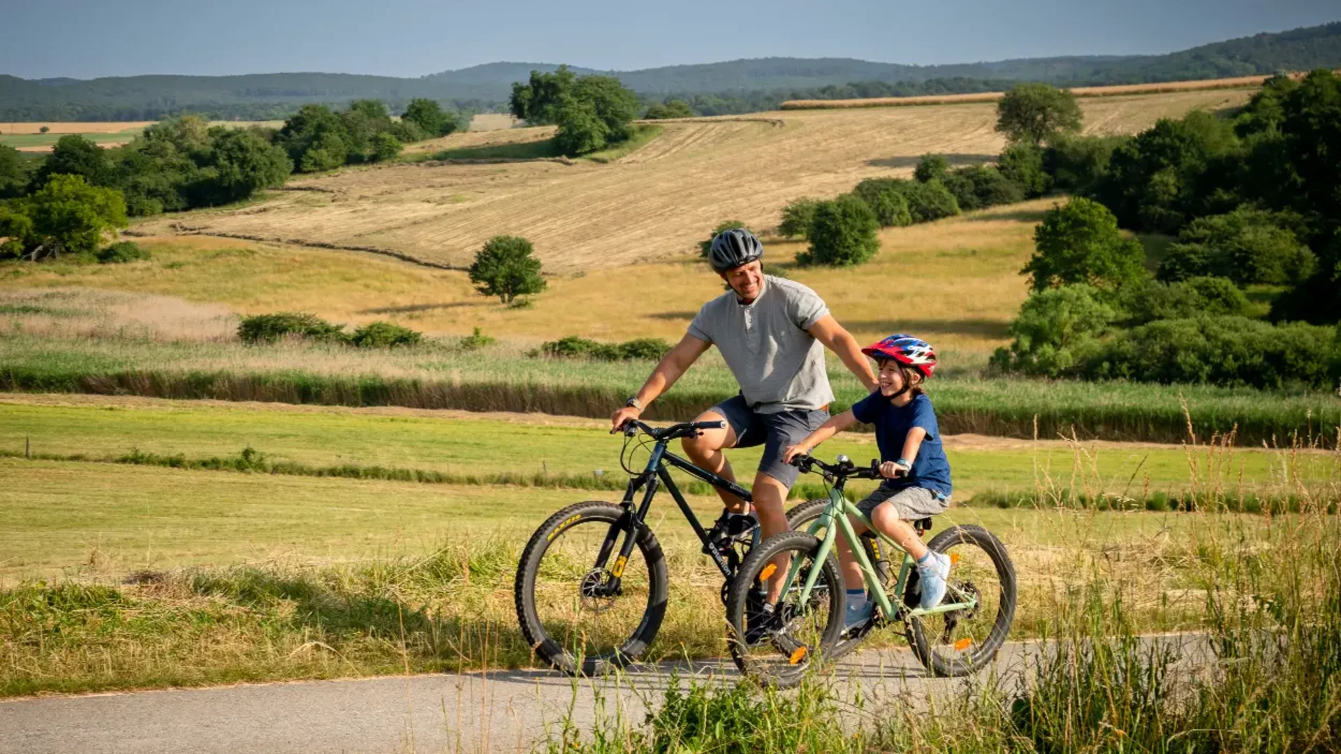 B32 Rosalia-Radwanderweg © Andreas Hafenscher Vater und Sohn fahren mit Fahrrädern auf einem Landweg durch die Natur