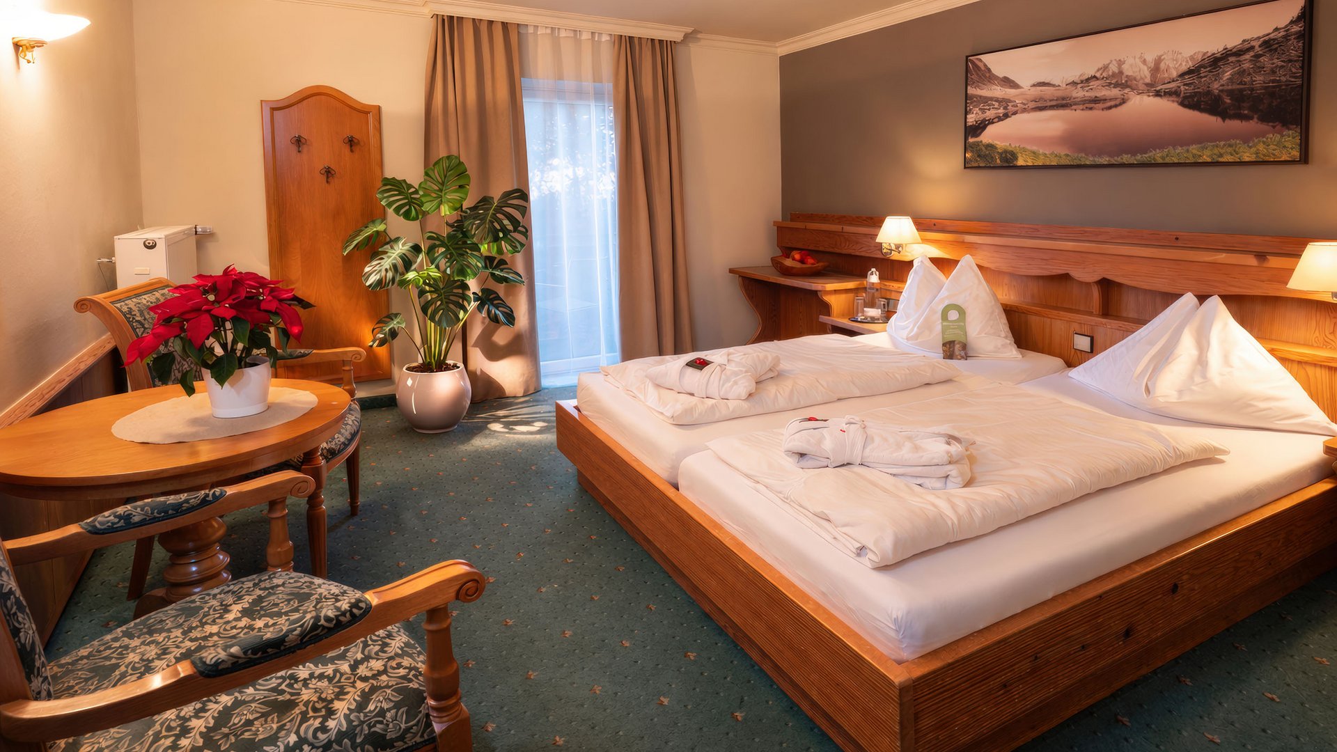 Cozy hotel room with double bed, table, chairs, and indoor plants