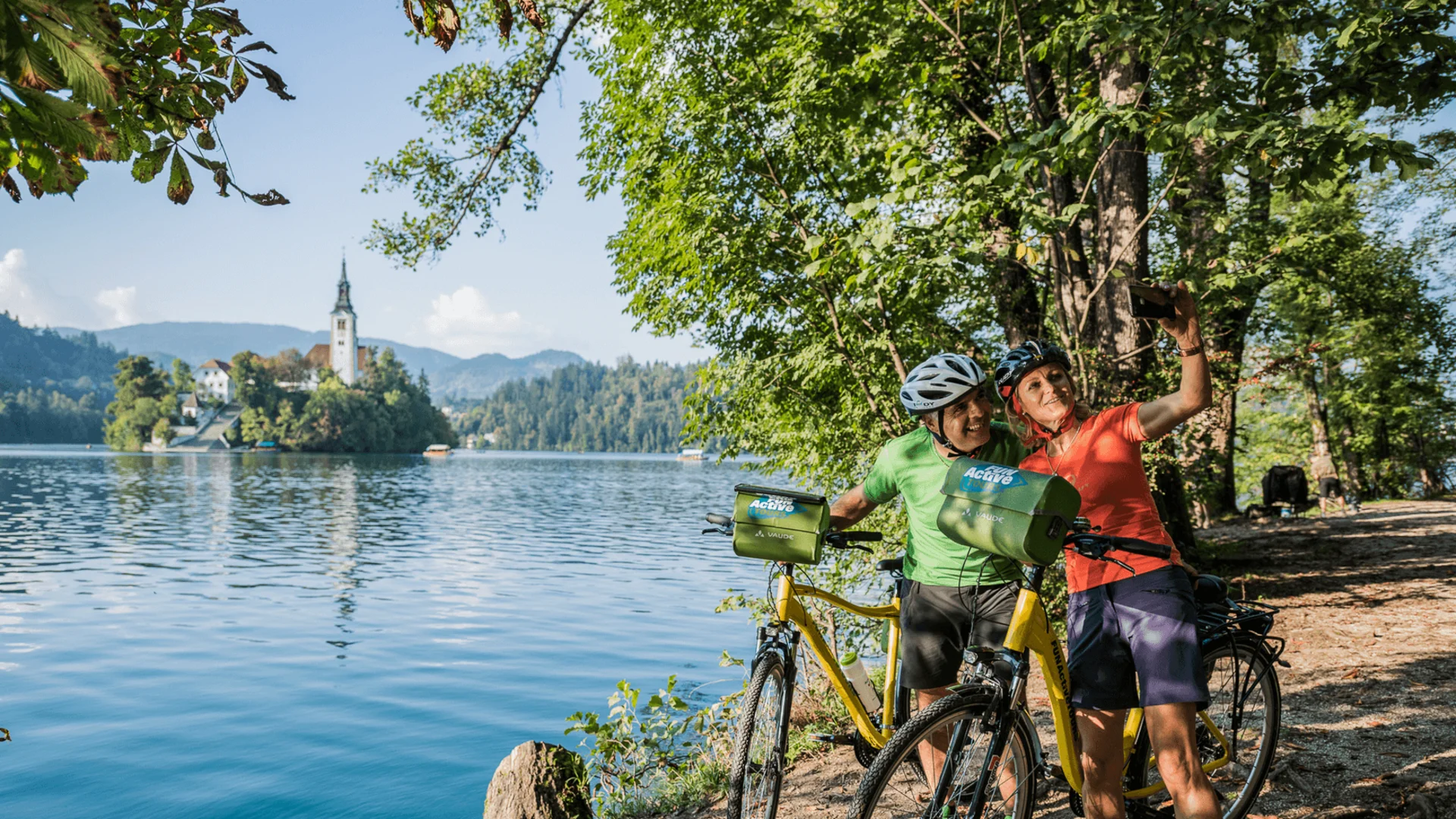 FunActive © FunActive Tours Two cyclists take a selfie at the lakeside on a sunny day