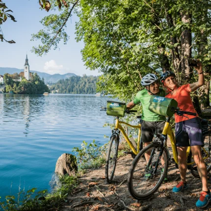 Twee fietsers maken een selfie aan de oever van het meer op een zonnige dag