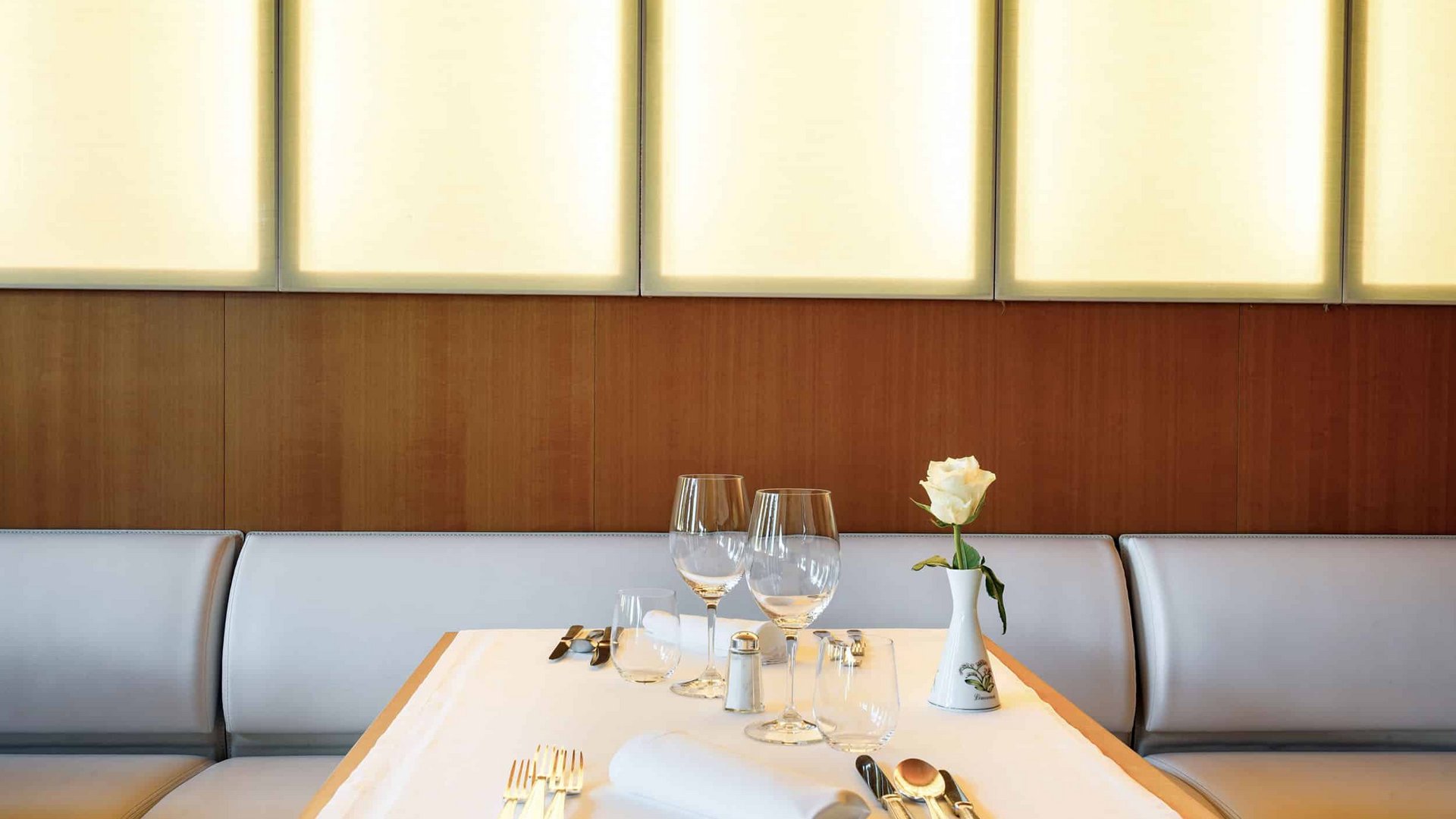 Elegant set table with white rose in a modern restaurant