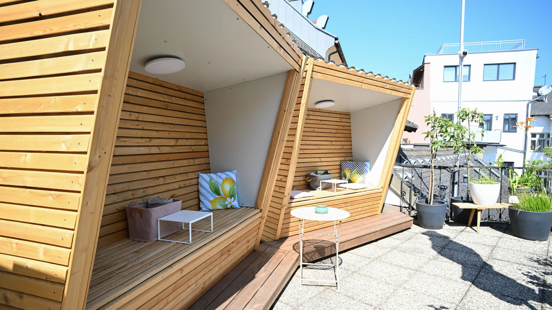 Moderne houten zitplaatsen met kussens op zonnig terras